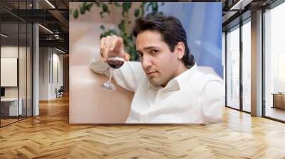 Portrait of the young attractive man with glass of red wine Wall mural