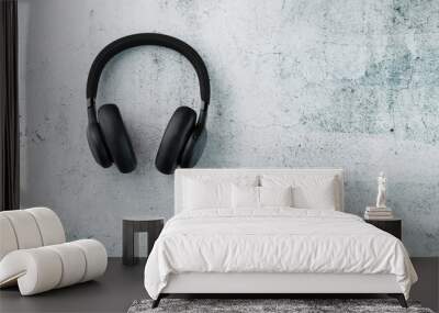 Wireless Black Headphones on a gray stone background. View from above. In-ear headphones for playing games and listening to music tracks Wall mural