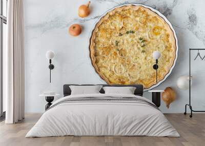 Flat lay of homemade onion cake on the white marble background. Quiche pie with steamed onions cheese and bacon Wall mural