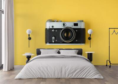 Old retro camera on the yellow background. Stylish background for a photo enthusiast. Flat lay Wall mural