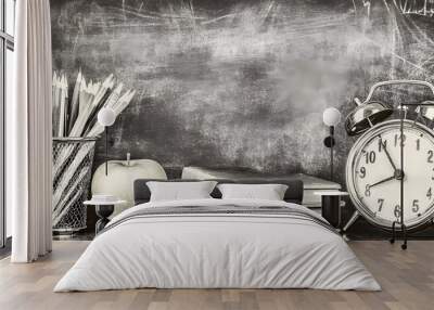 A black and white photo of a desk with a clock, a pencil holder, and a book Wall mural