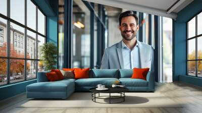 A man in a suit and tie is smiling and standing in front of a window Wall mural