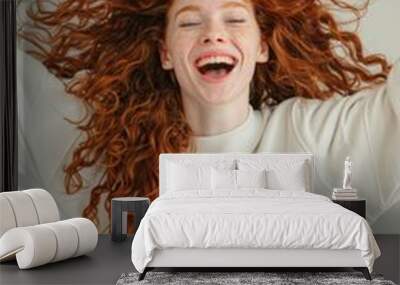 A woman with red hair is smiling and laughing while wearing a white shirt Wall mural