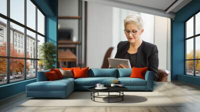 beautiful stylish woman aged with a tablet in her hands at work Wall mural