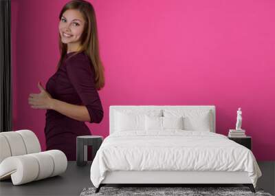 beautiful young girl with a smile on her face with flowing hair on a pink background Wall mural