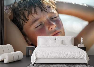 Cute boy relaxing by pool with sun protection on skin. Wall mural