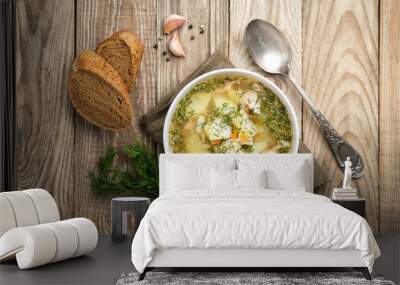 Fresh homemade fish soup with vegetables in bowl on rustic wooden background, top view with copy space. Wall mural