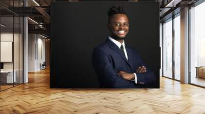 handsome young african man in suit on black background Wall mural