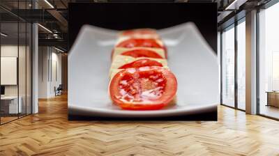 Tomatoes with cheese and olive oil on a white plate Wall mural