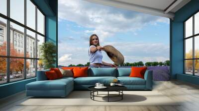 Young woman throwing hat in lavender field Wall mural