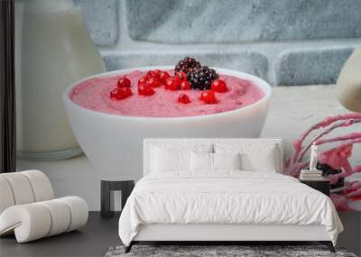 Mousse of semolina and red currant berries in a white bowl against a gray wall. Vegan dessert. Close-up. Wall mural