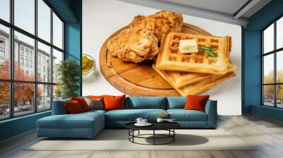 Pieces of fried chicken and waffles with butter on a round wooden board. Light table. Wall mural