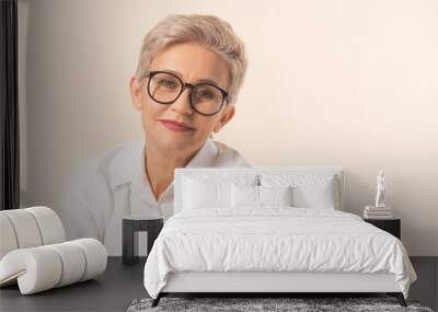 stylish beautiful woman with a short haircut, in a white shirt on a beige background Wall mural