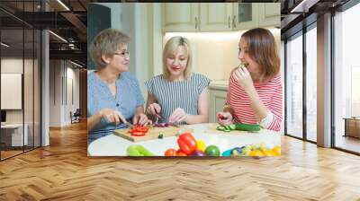 three funny women cut salad in the kitchen Wall mural