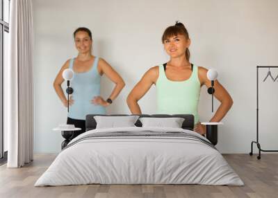 two beautiful adult women doing yoga at home Wall mural