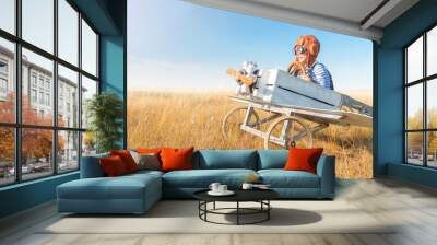 Little boy is playing the plane.
Happy and funy child imagines himself an aircraft pilot and plays in a aviator costume in an open-air field against a blue sky on a summer sunny day.  Wall mural