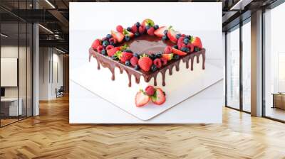 Square cake on birthday decorated with fresh berries, poured with chocolate on a white background. Wall mural