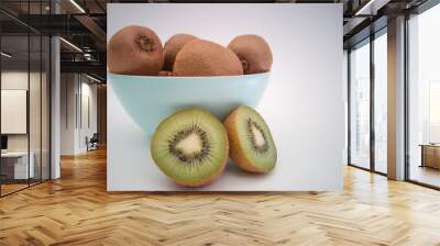 A light blue bowl with fresh kiwis on white background. Half of the kiwi.
 Wall mural