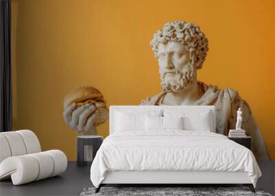 Classical greek statue with intricate details holding a modern fast-food hamburger against a vivid orange background Wall mural