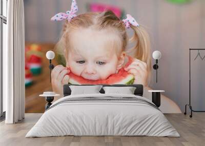 Cute little girl baby blonde eating juicy watermelon close-up Wall mural