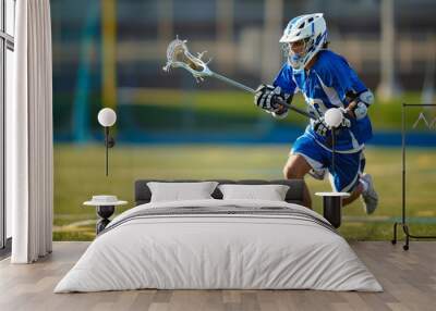 Focused lacrosse player in blue uniform sprints across the field, skillfully maneuvering the stick and ball during a competitive game Wall mural