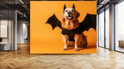 Golden retriever dog wearing bat costume with a black shirt and devil horns is sitting on an orange background Wall mural