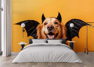 Golden retriever dog wearing devil costume with bat wings looking happy on orange background Wall mural