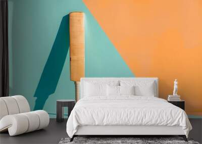 Modern minimalist still life of cricket bat and balls against a two-tone orange and teal background with shadows Wall mural