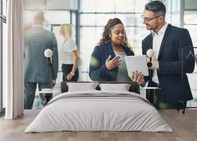 digital planning in action. shot of two coworkers talking together over a digital tablet in an offic Wall mural