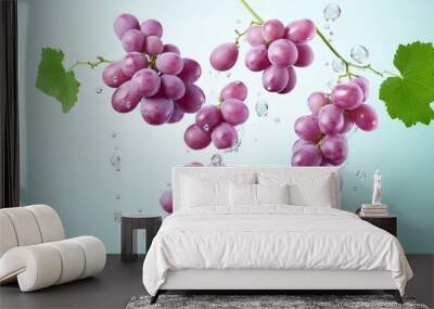 Bunches of grapes flying in the air with splashes of water on light blue background Wall mural