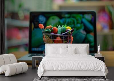 Vivid image of a miniature shopping cart filled with fresh produce on a laptop keyboard, symbolizing the convenience of online grocery shopping and e-commerce Wall mural