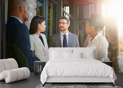 If we work together, well make a success of this. Shot of a diverse group of businesspeople having a meeting on a balcony in bright sunlight. Wall mural