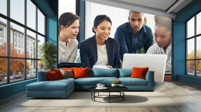 Theyre a team with a vision. Shot of a group of businesspeople talking together over a laptop during a meeting. Wall mural