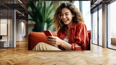 a woman laughing while holding a phone Wall mural