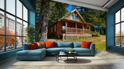 Log house of the Historic Taku Glacier Lodge, a wooden cabin located on the shores of a melt water lake in the mountains north of the Alaskan capital city Juneau Wall mural