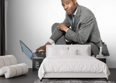 african man sitting on white background withe laptop Wall mural