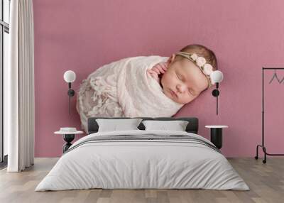 Sleeping newborn girl on a pink background. Photoshoot for the newborn. 7 days from birth. A portrait of a beautiful, seven day old, newborn baby girl Wall mural