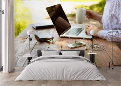 out of office work concept man sitting at vintage natural rough wood desk working on laptop computer Wall mural