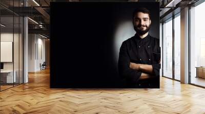 Professional chef with a beard in black uniform on a black background Wall mural