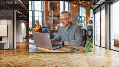 Confident Businessman Working on Laptop in Modern Office Wall mural