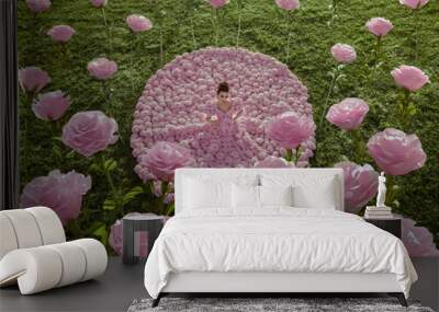 Beautiful woman in the dress of roses  in the garden with giant roses Wall mural