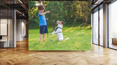 Preschooler kid boy doing dog obedience training classes with his pet Wall mural