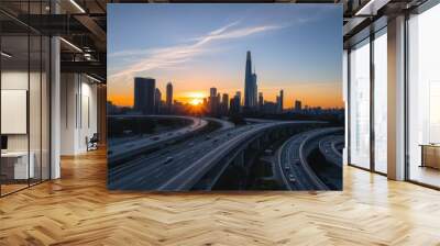 A drone shot of a bustling metropolitan area at sunset, with highways, skyscrapers, and people going about their day in the city. Wall mural