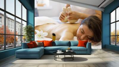 Woman enjoying body massage at spa club Wall mural