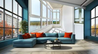 A sunny balcony with the panoramic windows in a new residential building on the high floor. A light loggia with white plastered walls without decoration Wall mural