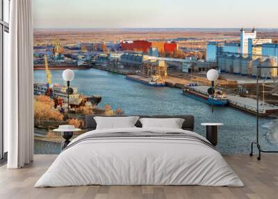 The panoramic view the river harbor with the big industrial building of grain elevator and  a cargo berth for loading grain onto bulk-carriers. International wheat trade Wall mural