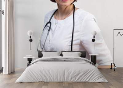 Woman medical worker in lab coat with glasses, white background. Wall mural