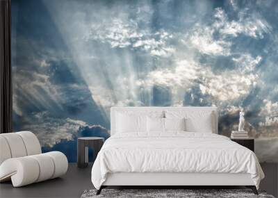 the sun's rays breaking through the clouds in straight lines against the sky and thunderclouds Wall mural