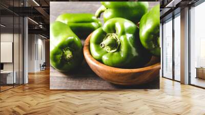 green organic paprika on wooden bowl/Fresh green organic paprika on wooden bowl over dark background. Close up. Wall mural