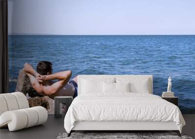 The young man relaxing on the beach Wall mural